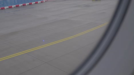 taxiing airplane on runway, yellow lines visible through window, airport scene