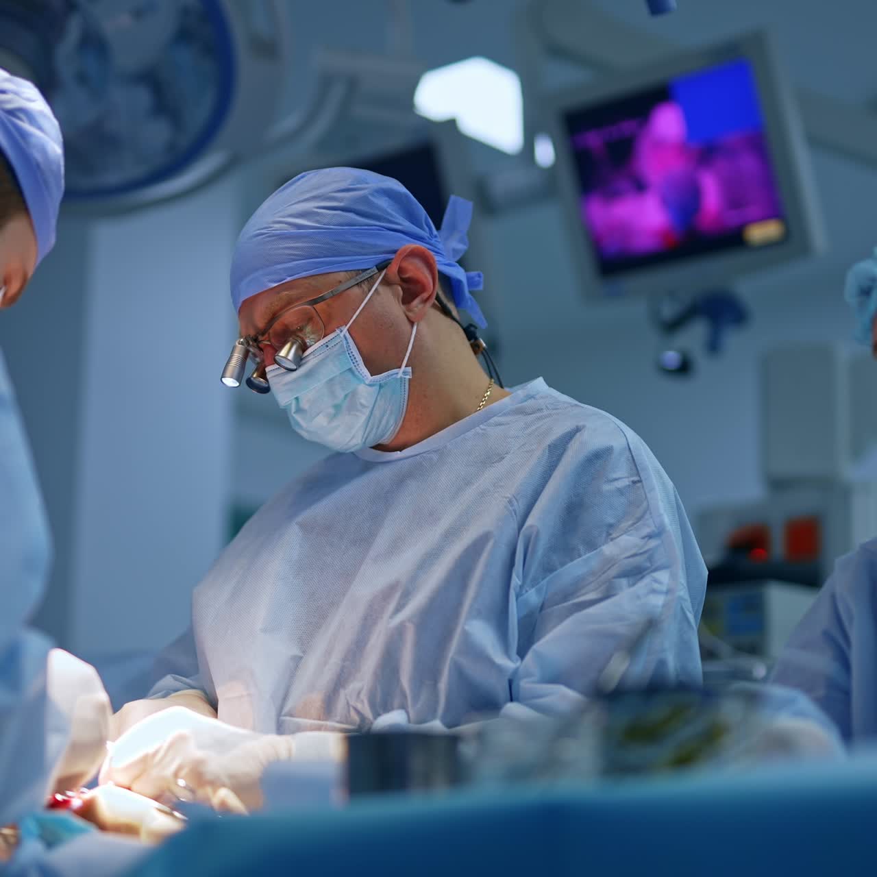 Two doctors co working in modern surgery room. Doctor in device glasses using metal tools. Nurse assisting the surgeons. Low angle view