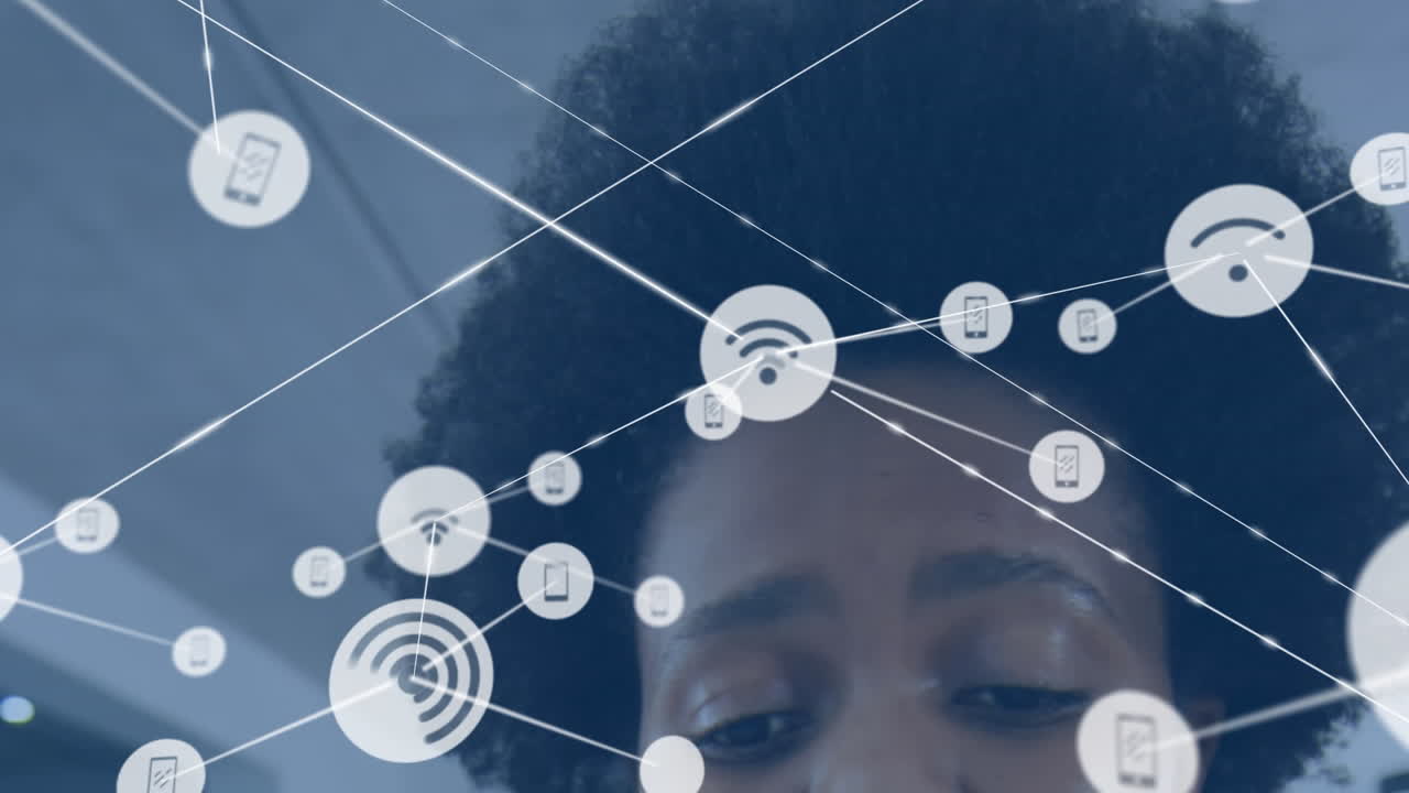 animación de una red de iconos digitales contra el primer plano de una mujer afroamericana en la oficina.