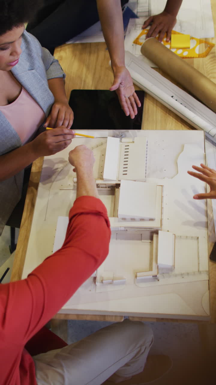 사무실에서 회의하는 동안 다양한 사업가들이 일을 논의하는 수직 비디오