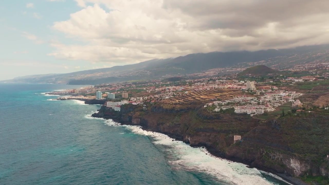 Vedute cinematografiche con drone delle acque cristalline di Tenerife, delle coste vulcaniche, delle spiagge dorate e delle vivaci atmosfere estive dell'isola, catturate dall'alto.