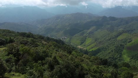 un adulto solitario caminando hacia un hermoso valle abajo y una cordillera nebulosa más allá