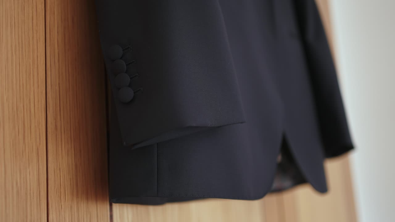 elegant jacket sleeve with fabric buttons rests gently on wood in soft natural light