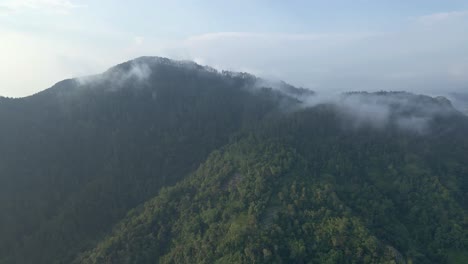 Drohnenflug-über-Wald-Und-Hügel-Mit-Dramatischem-Nebel,-Der-Den-Gipfel-Umhüllt