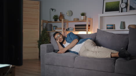 man sleeping on couch while watching tv