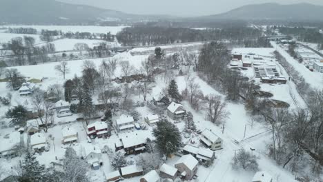 panoramic aerial flies over quaint suburb outside of downtown northampton covered in snow