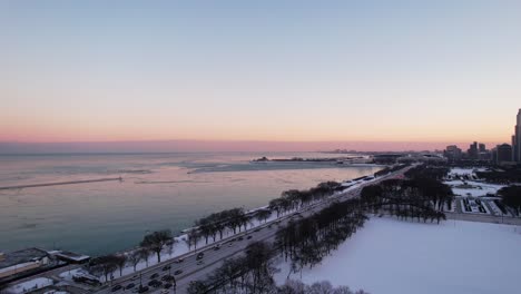 flying backwards over lakeshore drive highway from chicago and lake michigan at the sunset, rush hour