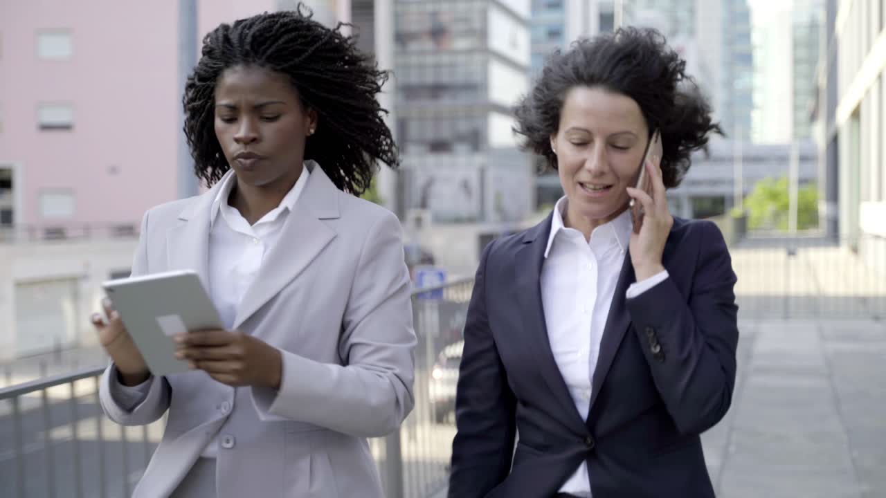 Femmes d'affaires sérieuses avec un smartphone et une tablette tactile