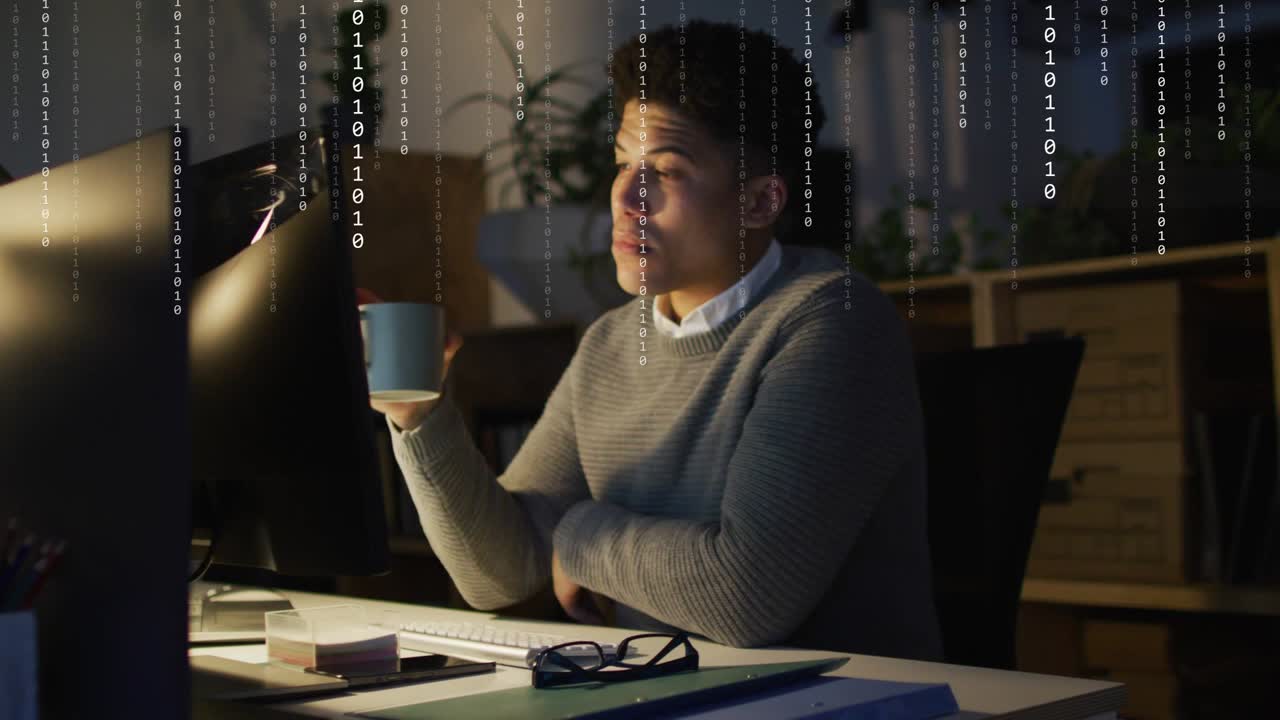 Male developer reaching keyboard while checking screen, sipping mug while binary overlay appearing