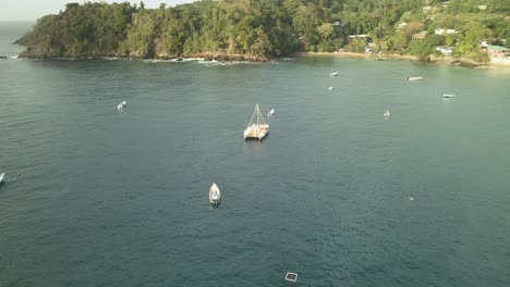 Aerial-pan-of-a-yacht-anchored-in-Big-Bay-Castara,-Tobago