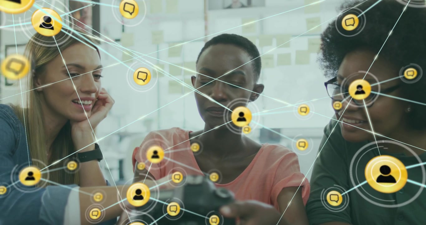 Animation of connected icons over diverse female coworkers sharing ideas in office