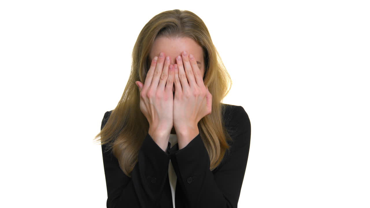 겁에 질린 소녀는 손으로 얼굴을 가리고 손가락으로 들여다본다