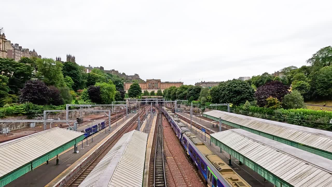 el tren se acerca en medio de la vegetación exuberante y los edificios históricos