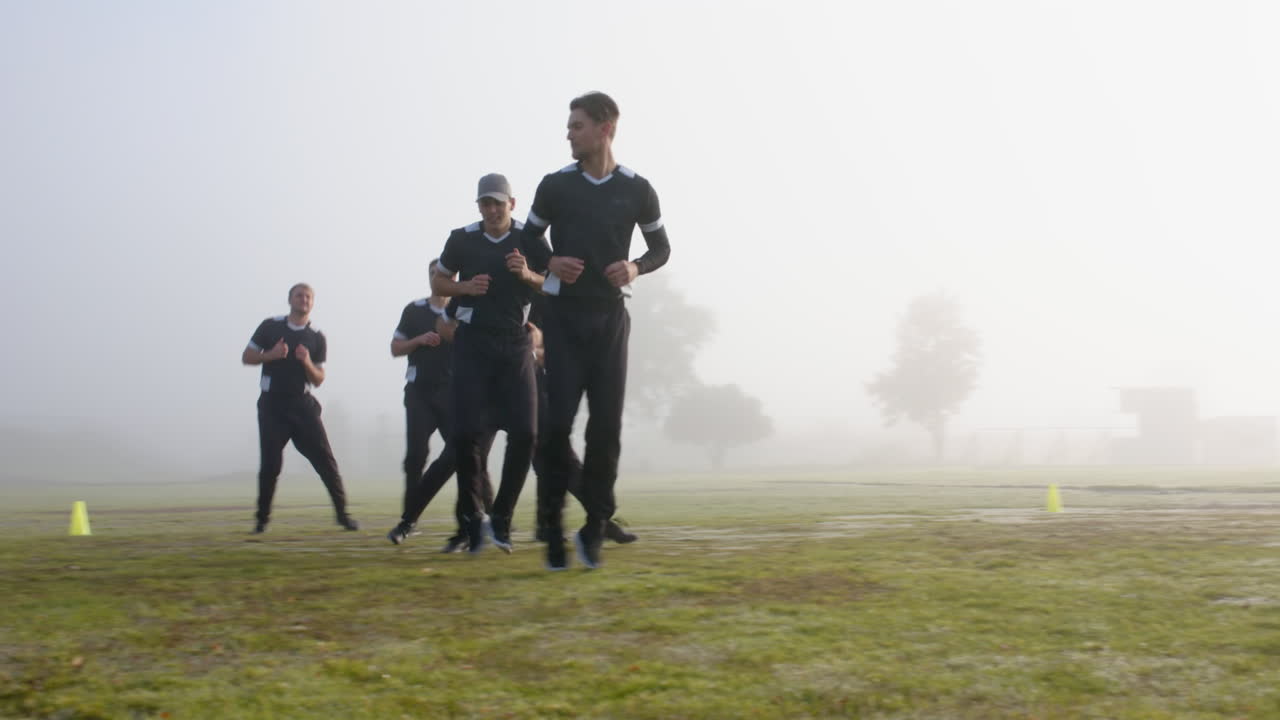 Playing cricket, group of men warming up on field in foggy weather