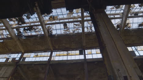 broken glass ceiling and windows inside an abandoned factory building