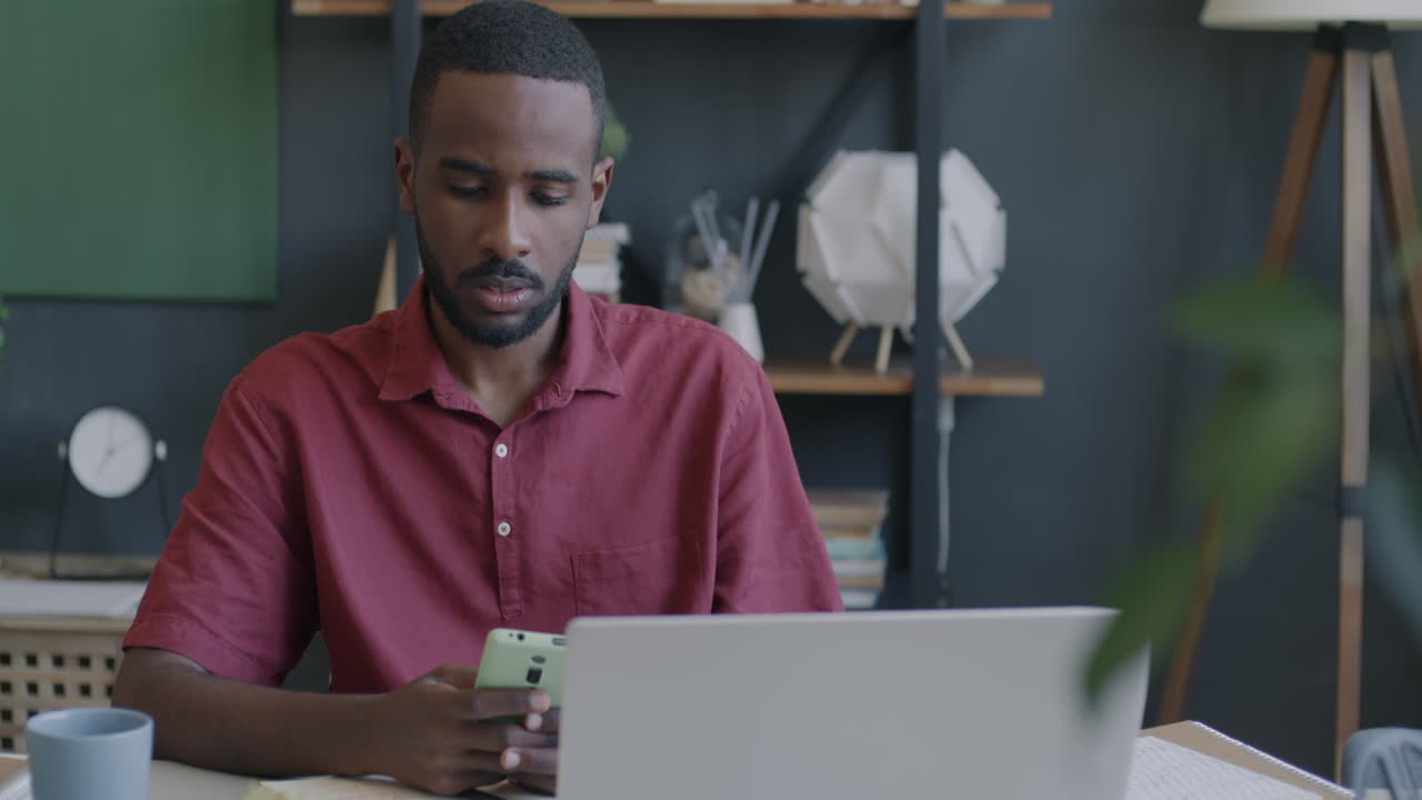Man Working on Laptop and Smartphone in Office