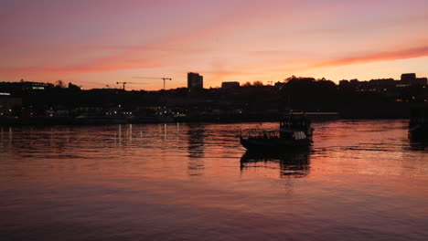 tourist boat silhouette approach on epic sunset lights porto riverside