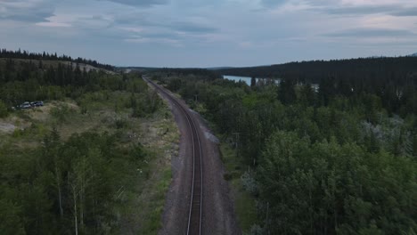 empty train track running through the stunning landscapes of kananaskis country in alberta, canada