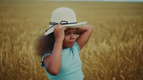 a young girl with a straw hat in a wheat field