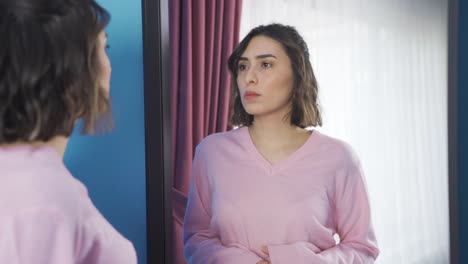 Angry-young-woman-who-finds-herself-guilty-in-front-of-mirror.