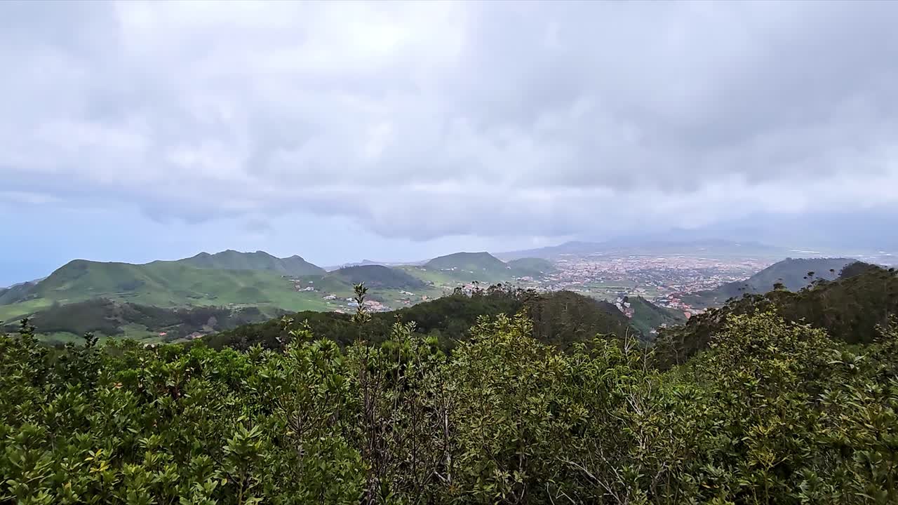 A scenic mountain view of the Anaga region with lush greenery and distant city views