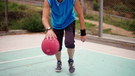 close up view of a young man practicing basketball outside. slow motion shot