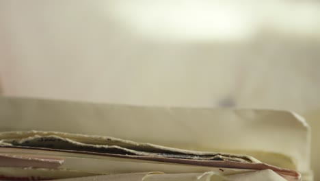 hand searching aged handwritten mail letters in home office archive close-up