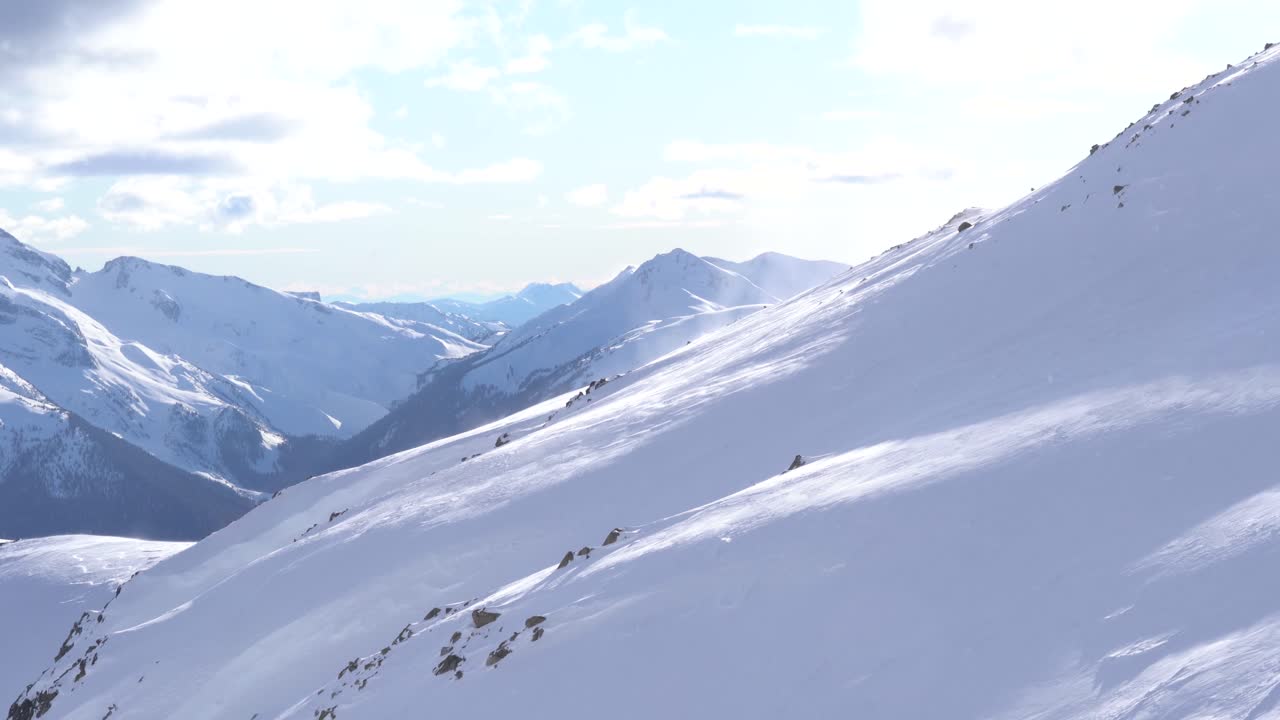 4K footage of snow blowing up the side of a mountain slope