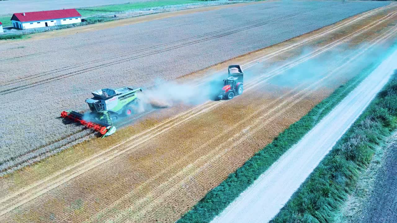 Imagem Aérea de Colheitadeira Descarregando Grãos de Milho em Reboque de Trator-3