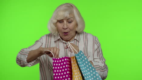 abuela mayor mostrando venta porcentaje de descuento inscripción publicitaria de la bolsa de compras