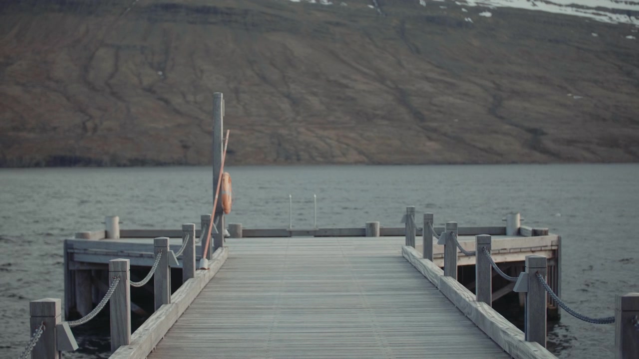 Empty Wooden Pier on a Serene Lake with Distant Mountains