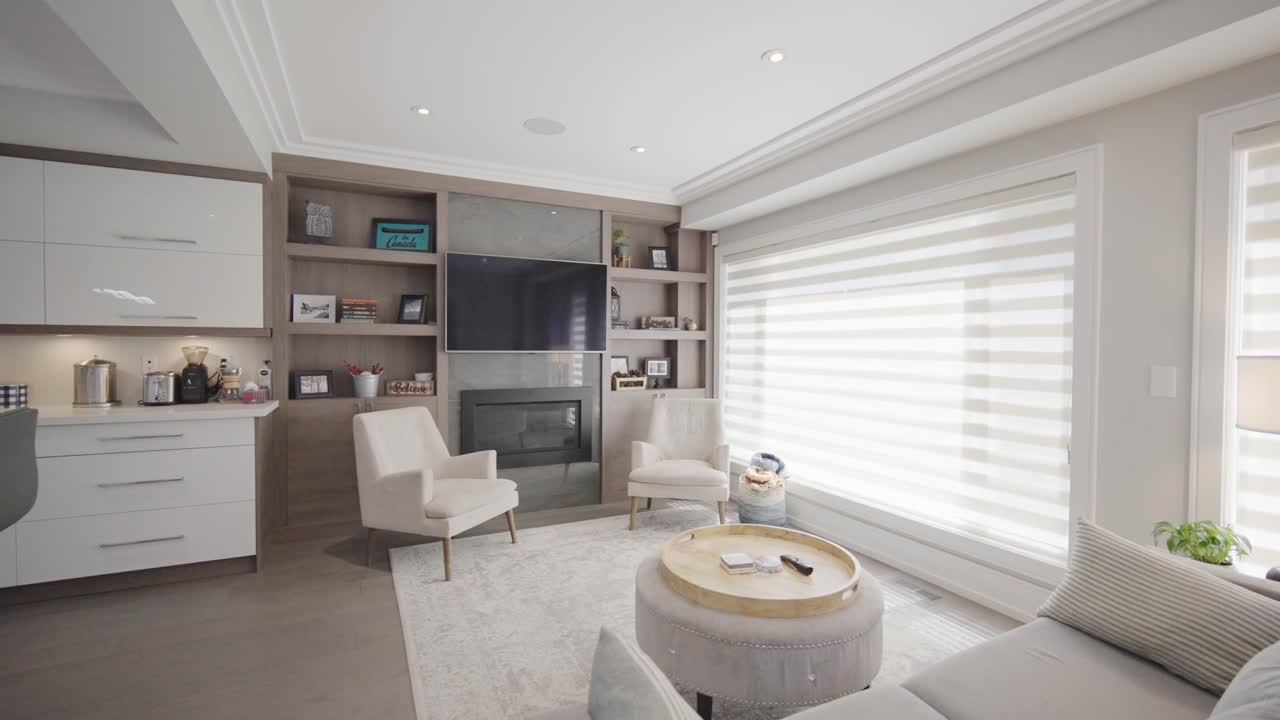 camine hacia una acogedora sala de estar detrás de la cocina con un sofá y una mesa de café y dos sillas en el medio en una casa