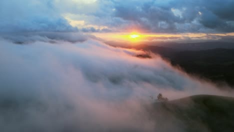 flying through cloud and mist above mountain valley at sunset, 4k aerial drone