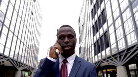 handsome busy black american manager talking by phone in the city