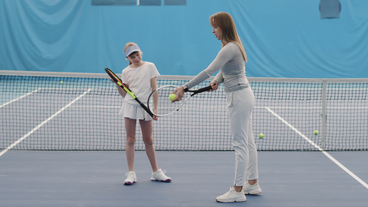 Little Girl Practicing Tennis Indoors