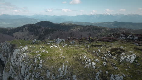 hiker walking on top of mountain ratitovec towards the rock to have a rest