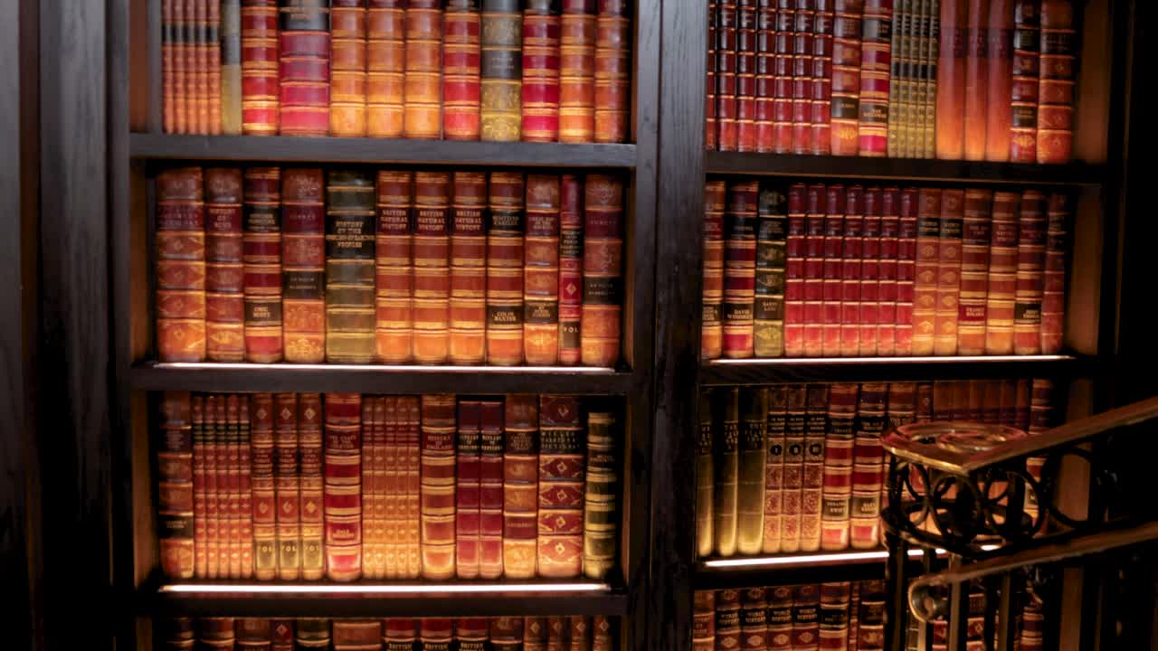 Black lady walking through a hidden passageway in a book case in the lounge of the Banff Fairmont hotel
