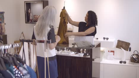 fair haired woman buying clothes in fashion store