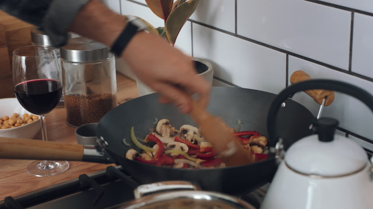 mano de pimienta, hongos y hombre cocinando vegano