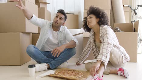 pareja joven comiendo pizza y charlando