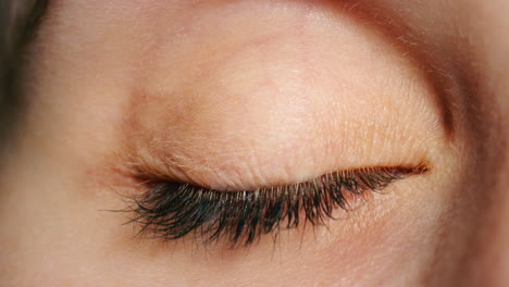 Woman-open-blue-eye,-in-close-up-showing-veins