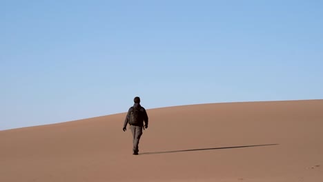 Hombre-Caminando-Sobre-Dunas-De-Arena-En-Cámara-Lenta