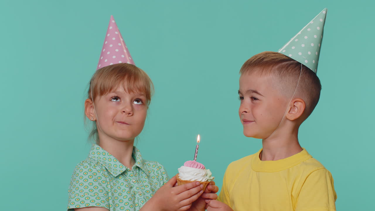 Bambini felici, ragazzi, ragazze, fratelli, amici che festeggiano il compleanno, che soffiano le candele sulla torta, che fanno un desiderio.