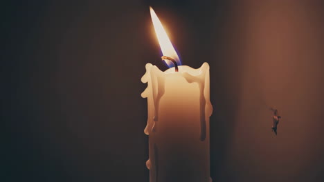 una vela ardiendo en la oscuridad