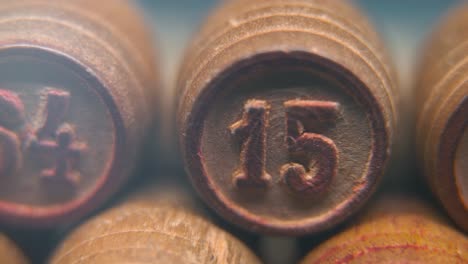 cinematic macro smooth shot of bingo wooden barrels in a row, woody figures, old numbers vintage board game, number 15, slow motion, commercial gimbal movement, pan right