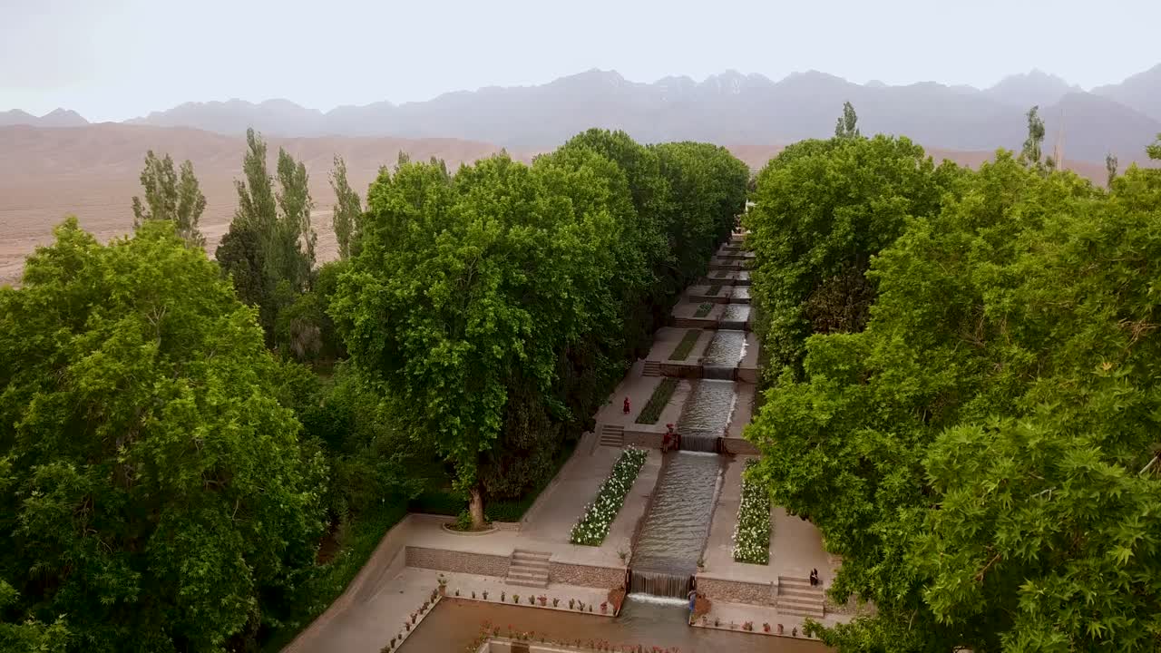 aterrizaje aéreo en un hermoso jardín con flujo de agua corriente en un desierto seco con paisaje montañoso