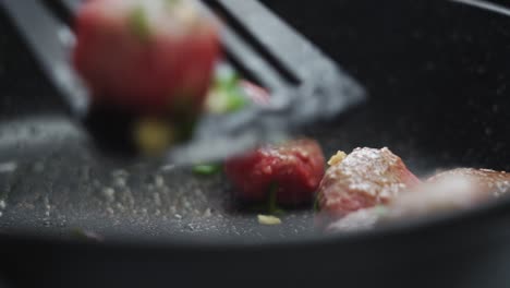 unrecognizable person cooking meatballs on frying pan with oil