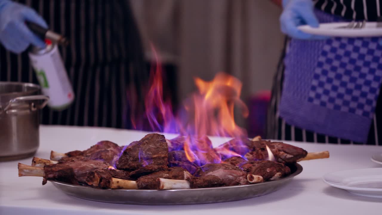 Table with food in restaurant. Close up of burning meat in restaurant