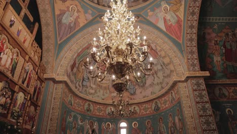 chandelier inside the orthodox church with painted ceiling and walls