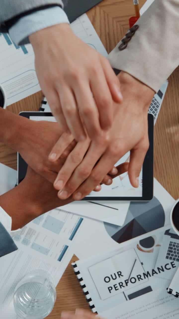 Persone in Affari che Impilano le Mani sulla Scrivania per il Lavoro di Squadra